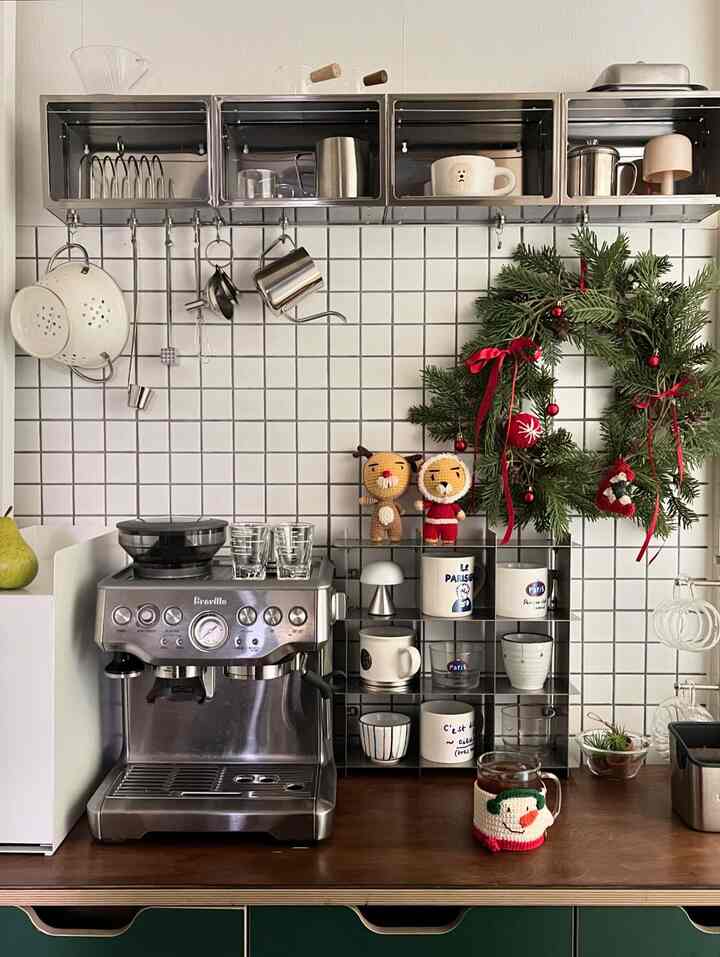 Modern and minimal kitchen home cafe featuring stainless steel cup racks and espresso machine on white tiled wall and brown wooden countertop