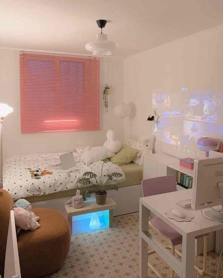 白とピンクの色調の小さな子供部屋、ラグや間接照明、デスクとベッドが温かく居心地の良い雰囲気を醸し出している。