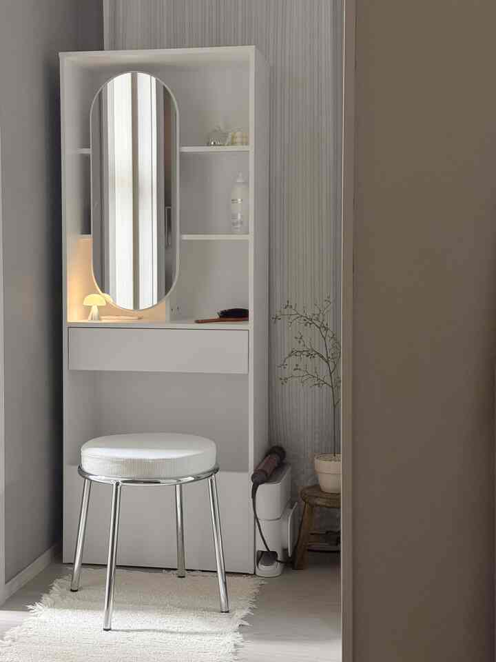 白とベージュのトーンが特徴的な狭い空間にすっきりとした化粧台とスツールが配置されたナチュラルなインテリア