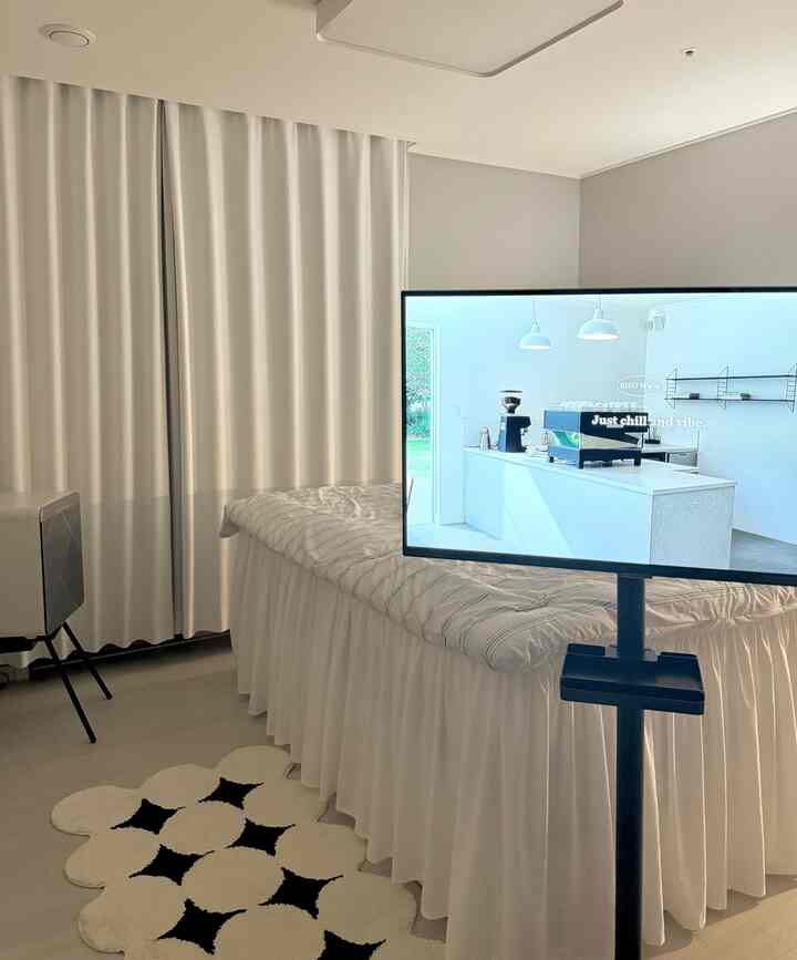 明るいホワイトとグレー調の子供部屋、中央にベッドと遮光カーテン、前方に特徴的な白黒のラグが配置された清潔感ある空間