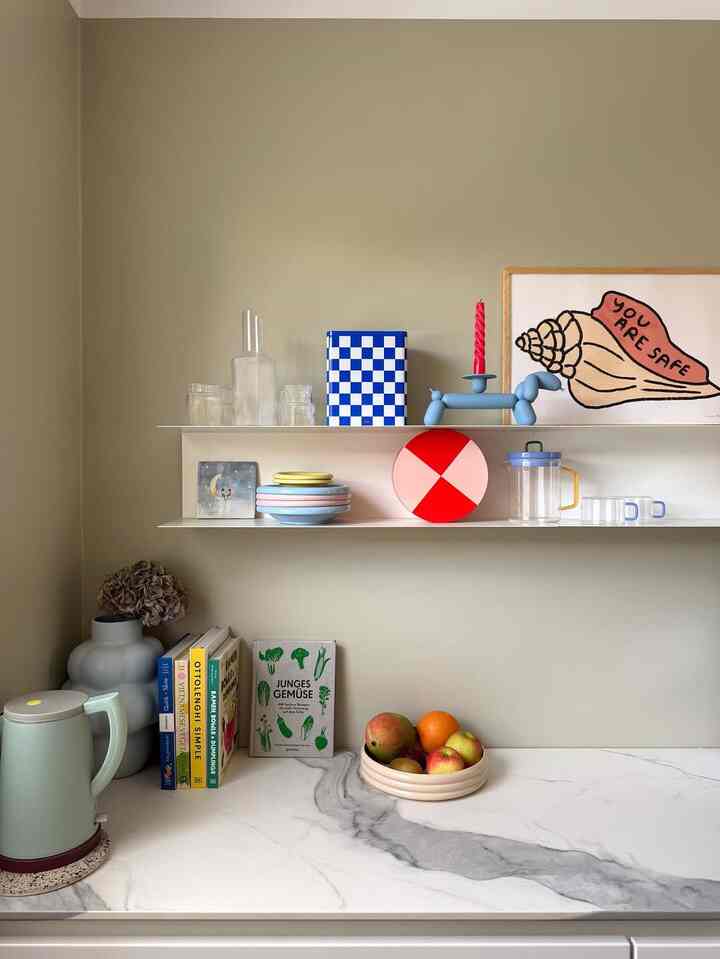 Beige-tone wall kitchen featuring marble-patterned countertop with objets and kitchen items, creating a cozy atmosphere
