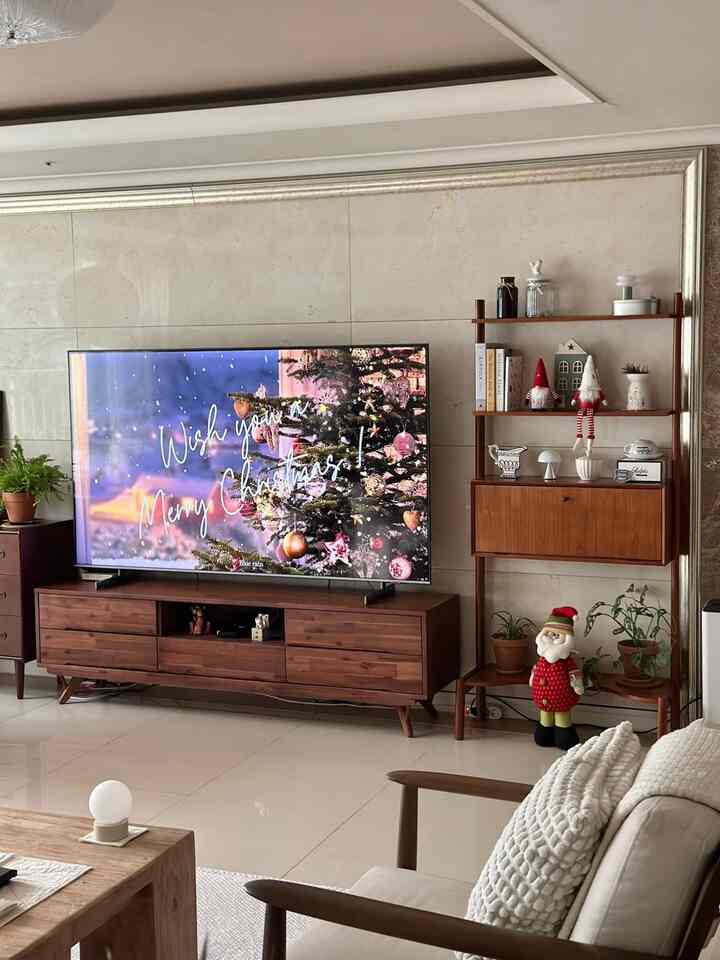 アイボリー色の床と木製家具が調和したモダンなリビング、クリスマスツリーや装飾が印象的な空間