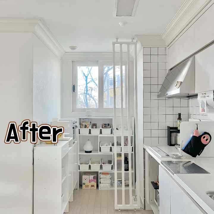 白とナチュラルトーンの狭いキッチン、窓下にフィットした棚と整理された収納が配置された印象的な空間