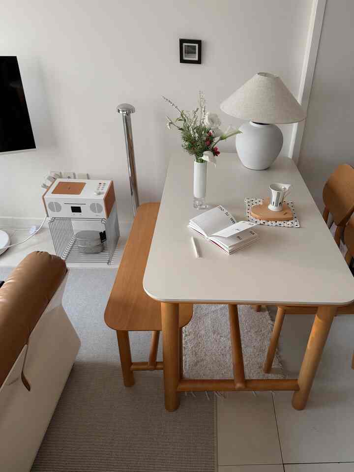 白と木目調の4人用ダイニングルーム、セラミック天板のダイニングテーブルと椅子、ベンチが配置されたナチュラルな雰囲気のインテリア