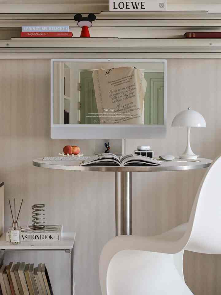 白とシルバーのトーンのホームオフィス、シンプルなデスクにコンピューターモニターとテーブルランプが配置されたモダンな雰囲気のあるインテリア