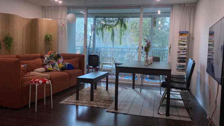 暖かいブラウン調のリビングとダイニング、広いソファとダイニングテーブル、自然の植物が配置された雰囲気のあるインテリア