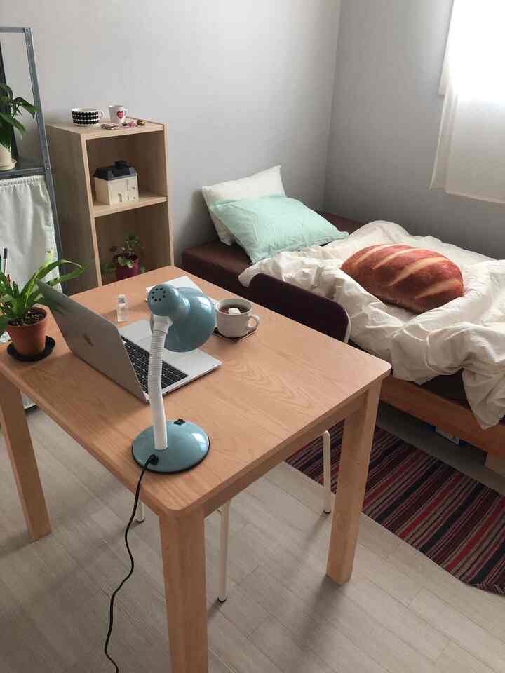 ナチュラルな木目調とベージュの色合いが調和した、一人用の寝室兼ホームオフィス、シンプルでコンパクトな印象のインテリア