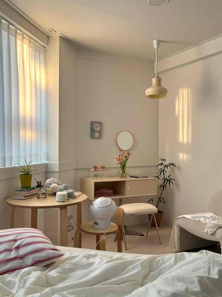 Cozy bedroom in soft beige tones featuring wooden furniture and plants with a simple, natural atmosphere