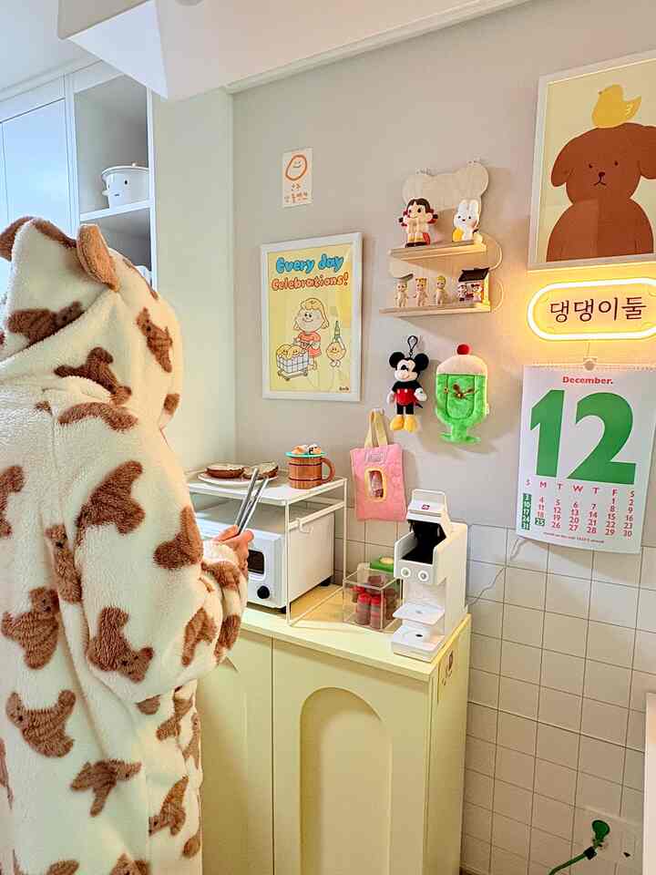 Kitchen space in white and brown tones featuring cute character decor and a coffee machine with a cozy atmosphere