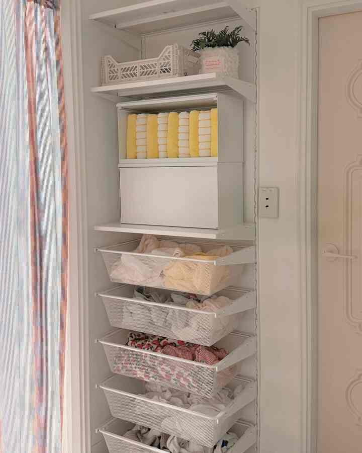 白を基調とした狭い部屋に、折りたたみボックスとメッシュ引き出しが整頓された収納家具が配置された雰囲気のあるインテリア