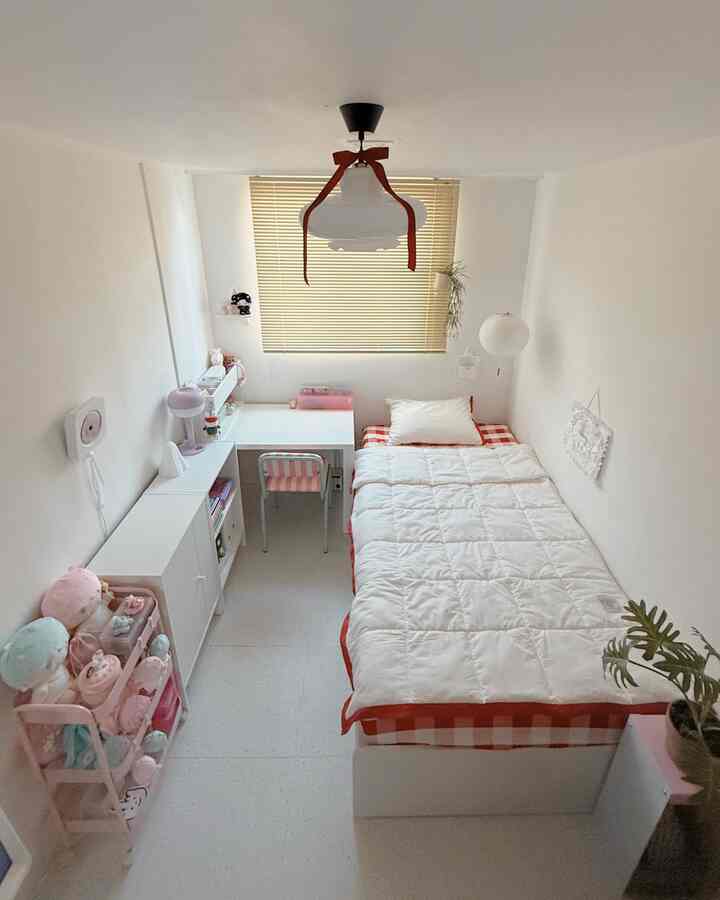 白と赤の色調の子供部屋、ベッドと子供用机、ブラインド、ぬいぐるみが配置された雰囲気のあるインテリア