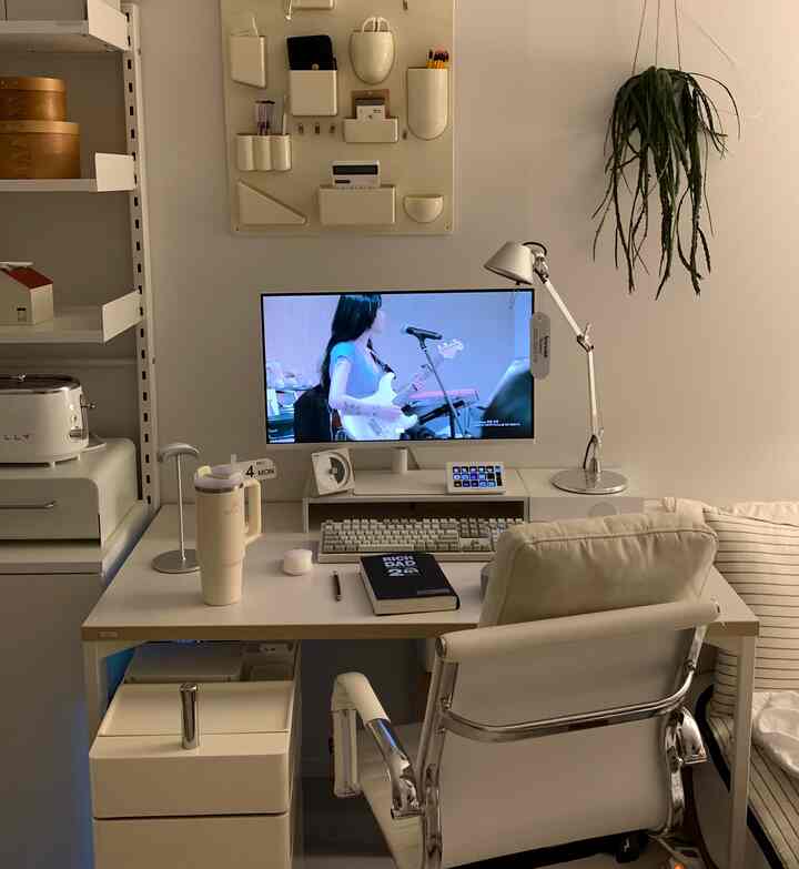 ホワイトとナチュラルトーンのホームオフィス、コンピューターモニターとオフィスチェアが配置されたシンプルで清潔感のある作業空間