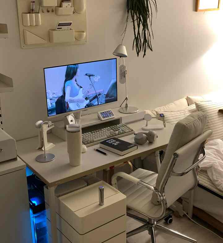 Monotone white and beige home office space featuring a desk, office chair, and modern sofa with a clean, calm atmosphere