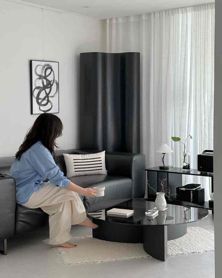Black and white toned living room featuring a modern sofa and coffee table with a simple and elegant atmosphere