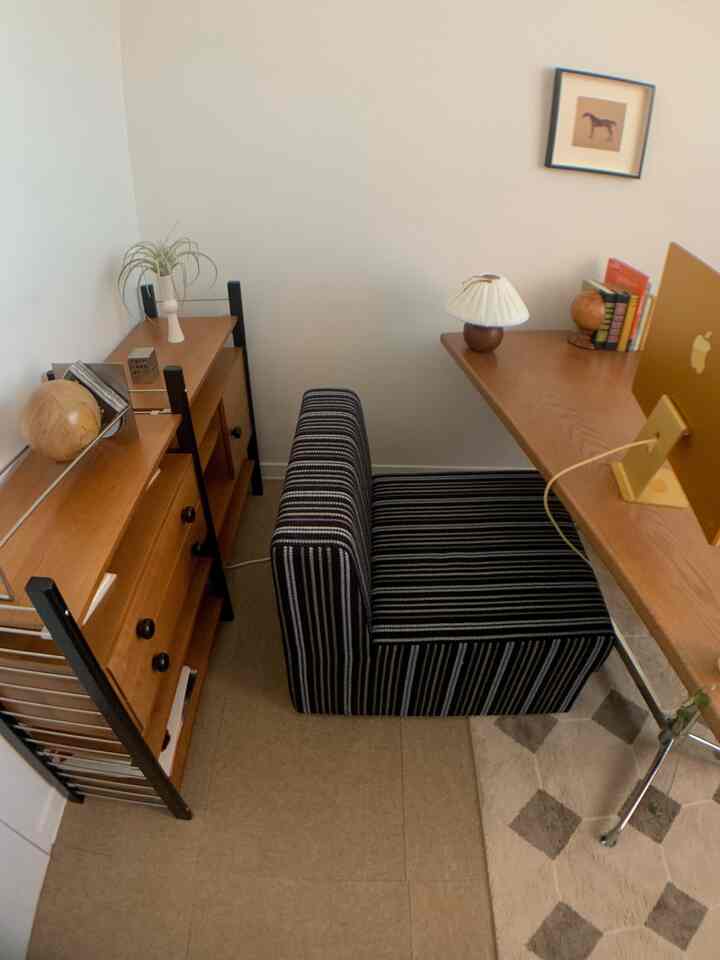 ナチュラルなブラウン調のホームオフィス、シンプルモダンな小さな部屋にデスクと本棚が配置された雰囲気のあるインテリア