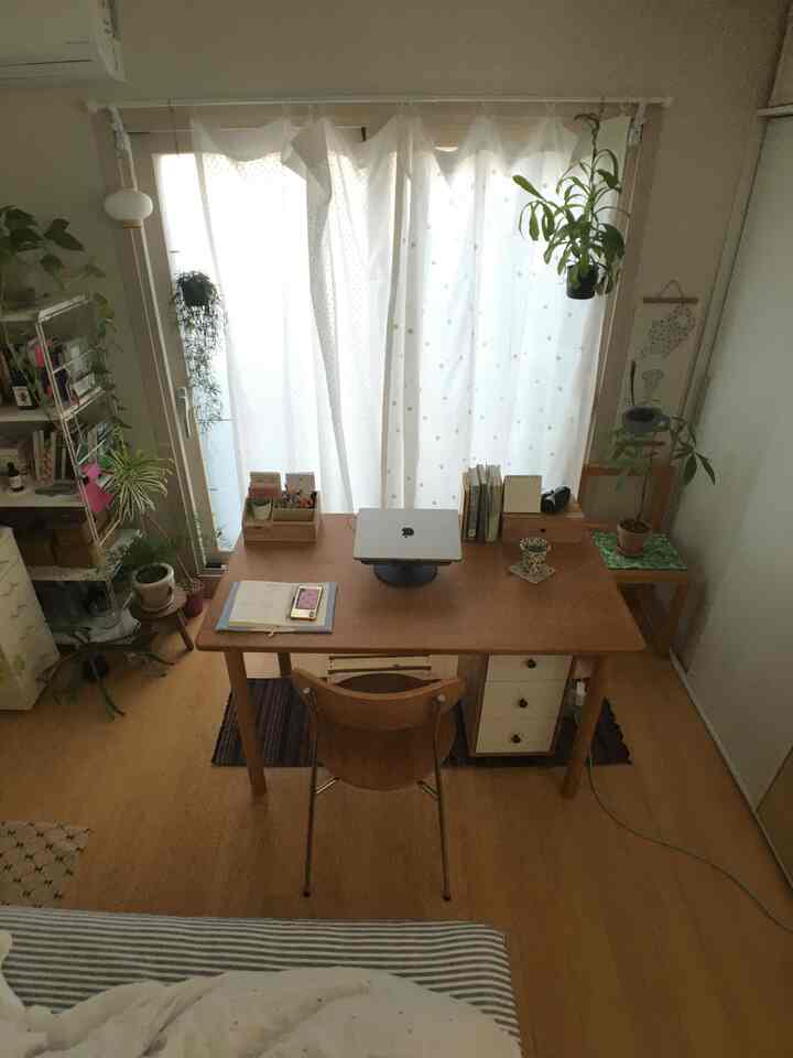 木目調と白色が調和した6畳のコンパクトなホームオフィス、机と椅子、植物が配置された落ち着いた雰囲気のあるインテリア