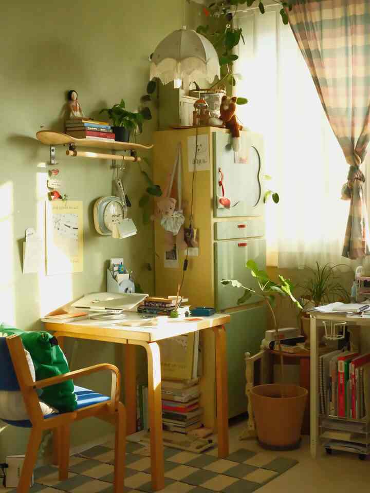 暖かいグリーンの壁と木の家具が調和するヴィンテージ風の書斎空間、日差しが差し込む居心地の良い雰囲気