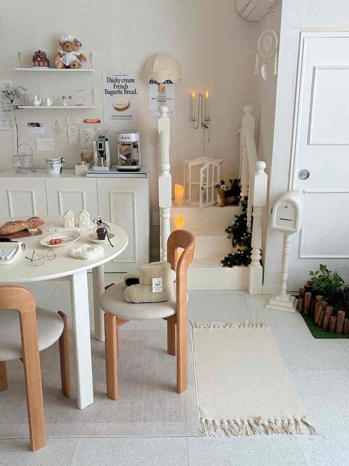 White and natural tone studio apartment home cafe space featuring stairs and dining chairs with cozy interior