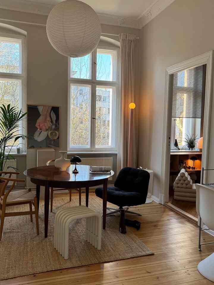 Modern dining room with white walls and wood-tone floors featuring a round table and chairs, creating a natural and cozy atmosphere