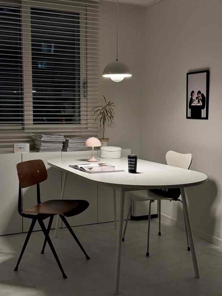 ホワイトとウッドトーンが調和したモダンなダイニング、テーブルや椅子、照明が配置された落ち着いた雰囲気のインテリア