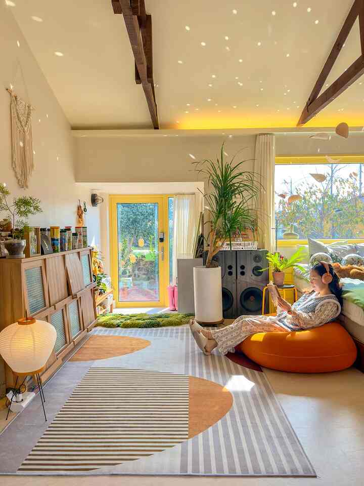 Cozy living room in yellow and wood tones featuring orange bean bag sofa and geometric rug with a warm ambiance
