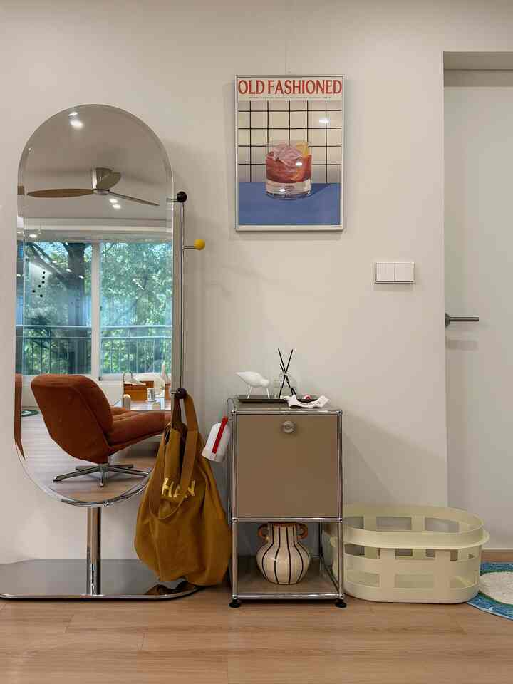 Natural color and simple designed entrance area featuring mirror, dresser, and laundry basket
