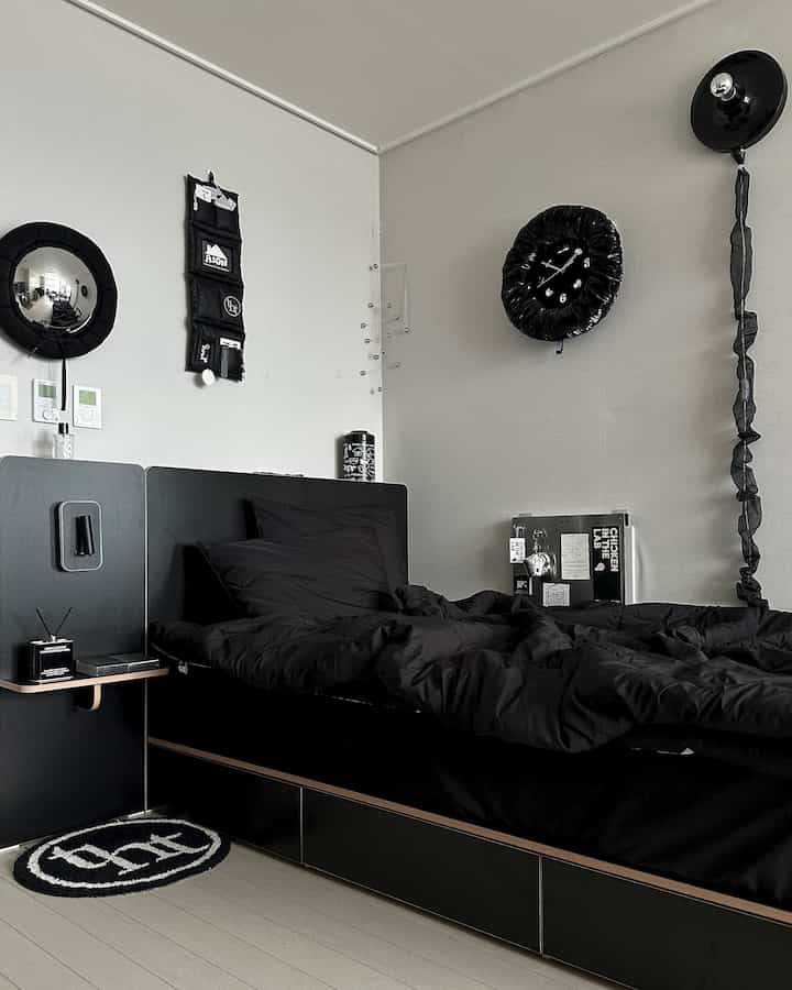 Modern bedroom featuring black bedding and bed with minimalist decor