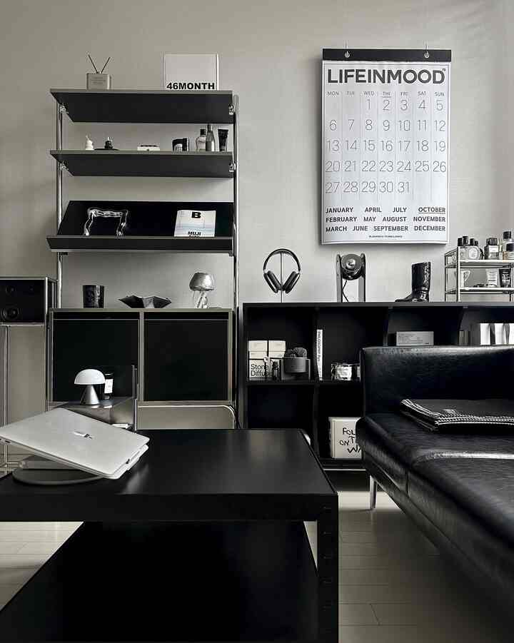 A modern black and white living room featuring modular shelving and sleek furniture in a clean layout