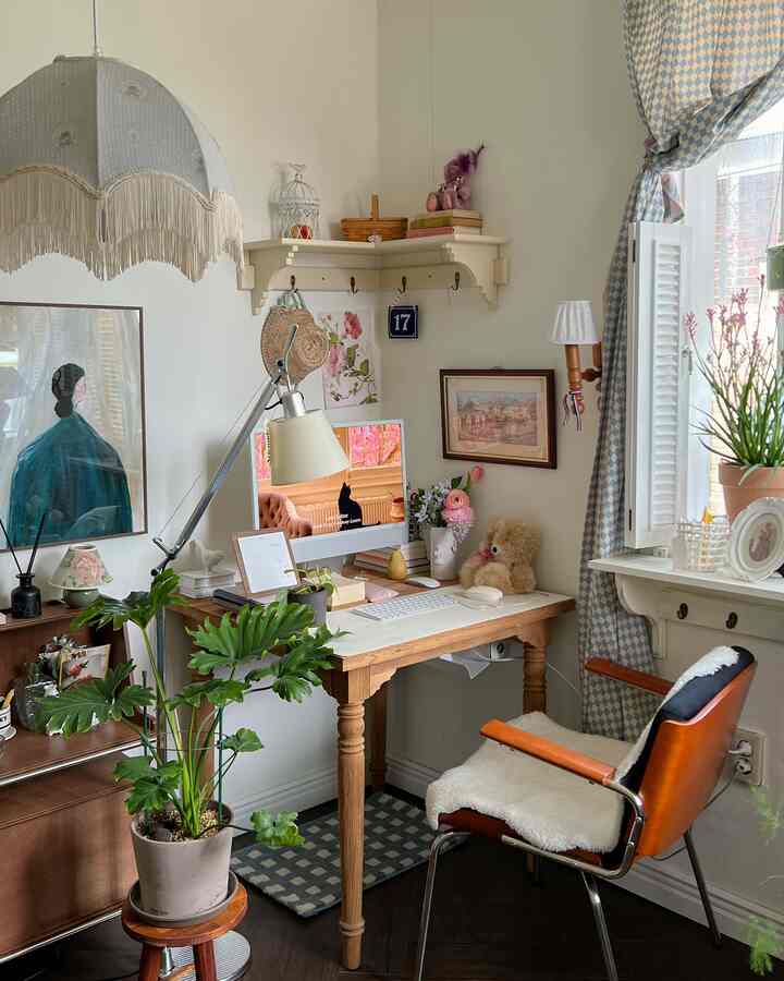 白い壁と木目調家具が調和したホームオフィス空間、コンピューターや植物、ヴィンテージの小物で温かみのある雰囲気