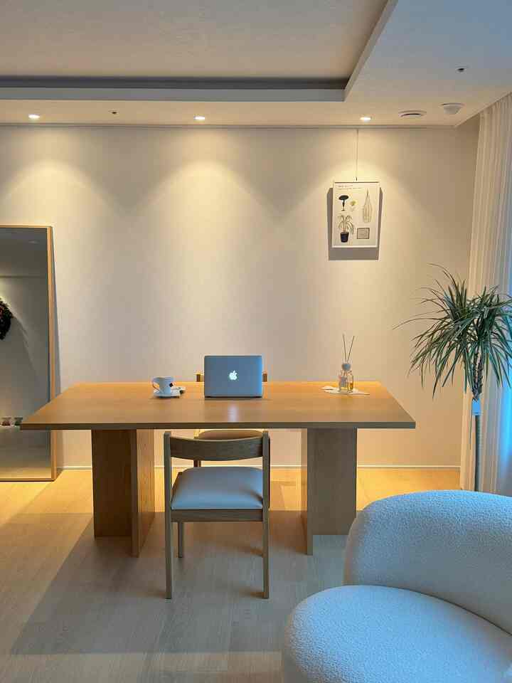 Bright wood tone and white living room featuring a dining table and chair with a simple and natural atmosphere