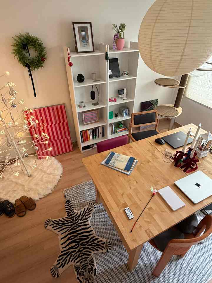 白とベージュのナチュラルな色調のダイニングルーム、本棚とキャットタワーが配置された雰囲気のあるインテリア