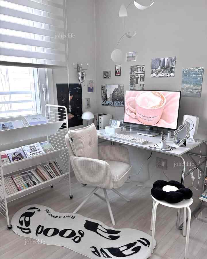 A clean, compact white and gray toned studio home office featuring a desk, cozy chair, and bookshelf