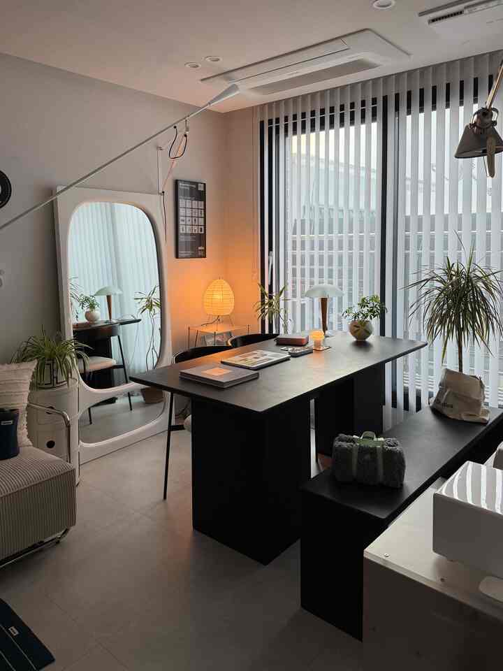 White and black toned home office and dining room featuring a modern black dining table and bench centrally arranged in a neat space