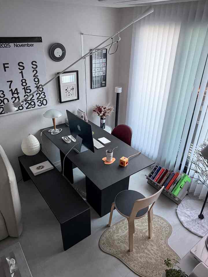 Modern home office in black and white tones featuring a focused desk setup with a clean, organized layout