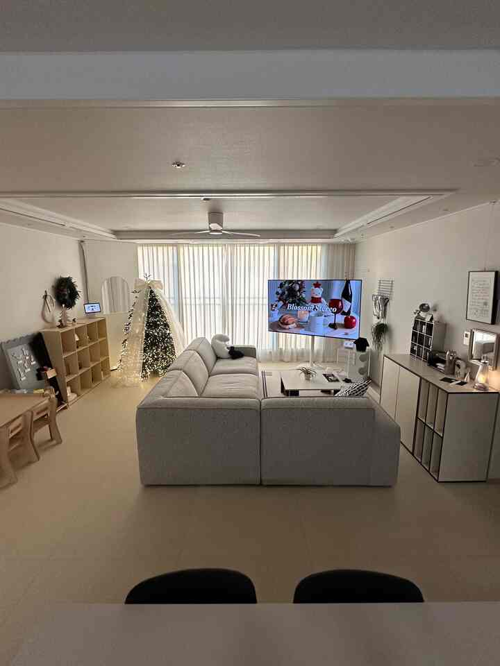 ホワイトとベージュの色調のリビング、モジュラーソファと区切られた赤ちゃんの遊びスペースがあるナチュラルモダンなインテリア