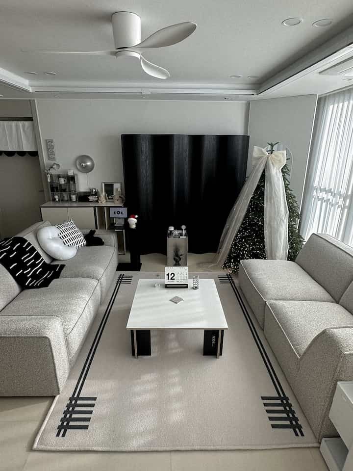 白とグレーのトーンのリビング、モジュラーコーナーソファとコーヒーテーブルが配置されたシンプルモダンなカフェ風のインテリア