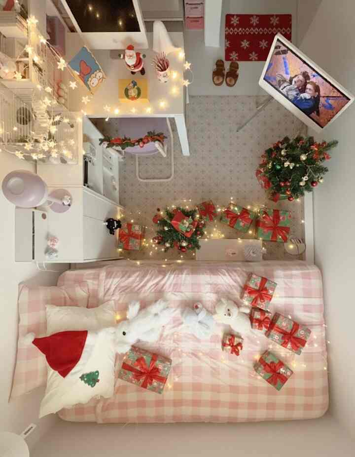 ピンクのチェック柄ソファベッドとクリスマスの飾りが配された暖かい一人暮らしの寝室