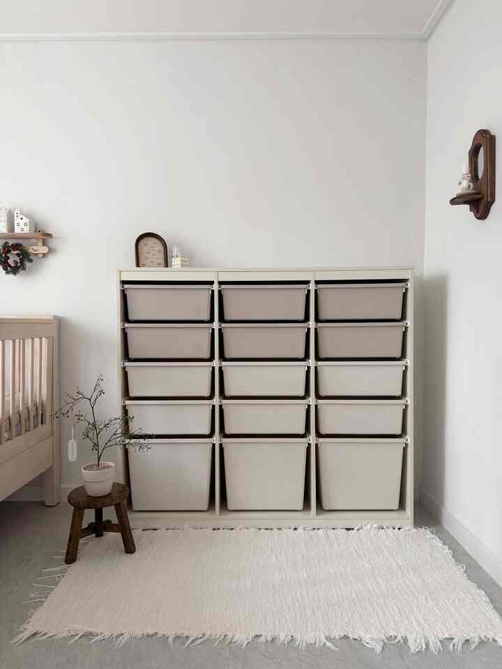 アイボリーとベージュの色調の子供部屋、キッズベッドと大小の収納ボックスが配置されたシンプルで清潔感のあるインテリア