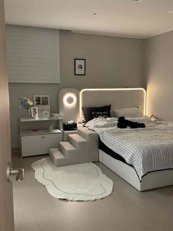 White-toned bedroom featuring a Mid-Century Modern bed and pet steps, creating a simple and cozy atmosphere