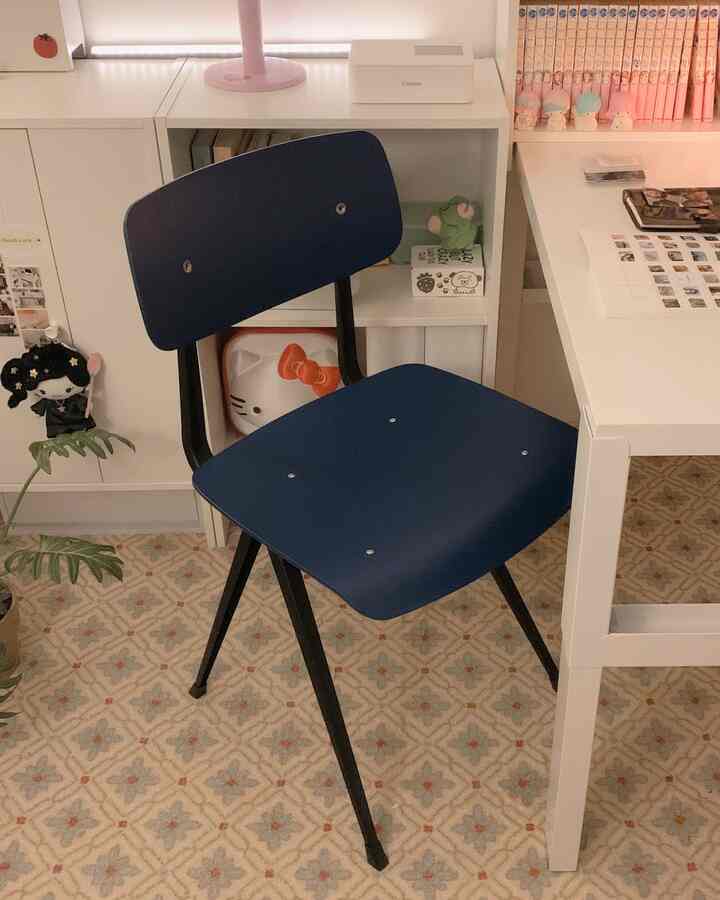 白い背景と青い椅子がある子供部屋、子供用机と本棚がかわいく配置された空間