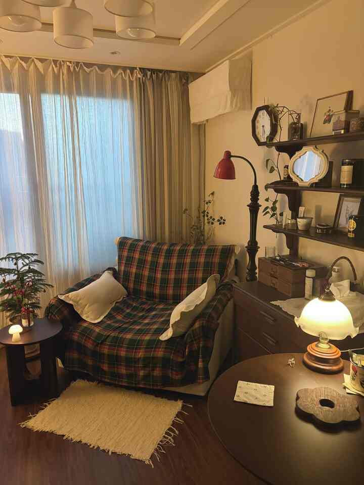 暖かみのある木目調とチェック柄のソファカバーが配置された居心地の良いリビングコーナー