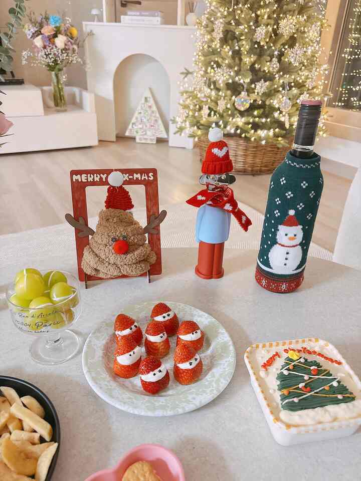 ホワイトと木目調のダイニング、クリスマスツリーとホームパーティーの料理が配置された雰囲気ある空間