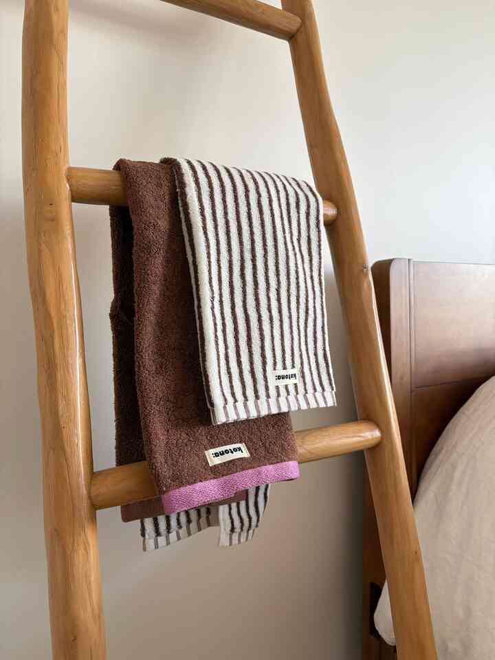 Cozy bedroom space featuring natural wood tones and brown-toned towels