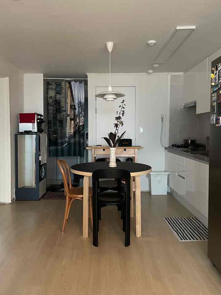 木目調と黒色のキッチン、アルテックアルトテーブルとトーンチェア18が配されたシンプルで整ったインテリア