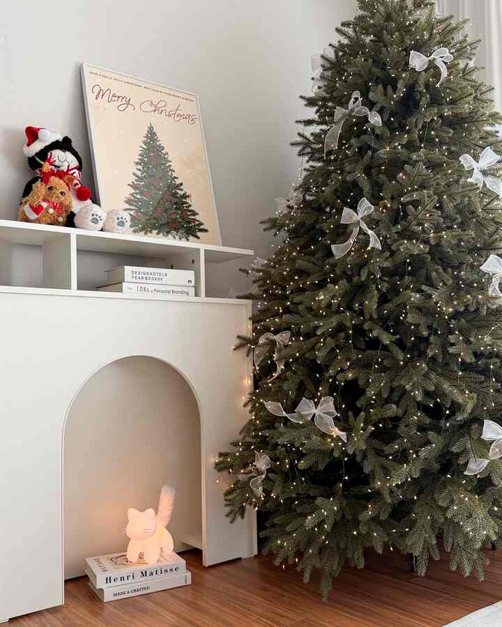 ウッドトーンの床と白い壁のリビング、クリスマスツリーと猫のムードランプが配置された雰囲気あるインテリア