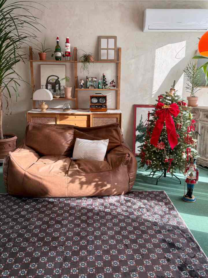 暖かいブラウンとナチュラルウッドが調和するリビング、クリスマスツリーが印象的な居心地の良い空間