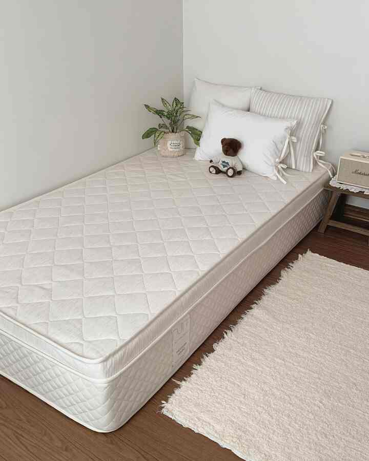 Natural wood tone flooring and white bedding in a 6-tatami bedroom with a simple and cozy atmosphere