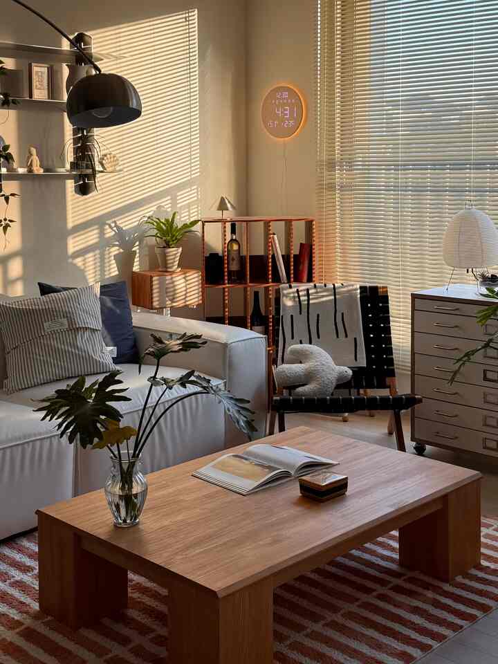 温かみのある木目調と白を基調としたモダンなリビング、レザーソファとラウンジチェアが配置された落ち着いた空間