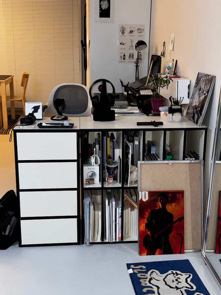 白と黒のトーンのホームオフィス、デスクやオフィスチェア、本棚、ブラインドが配置された整った作業空間