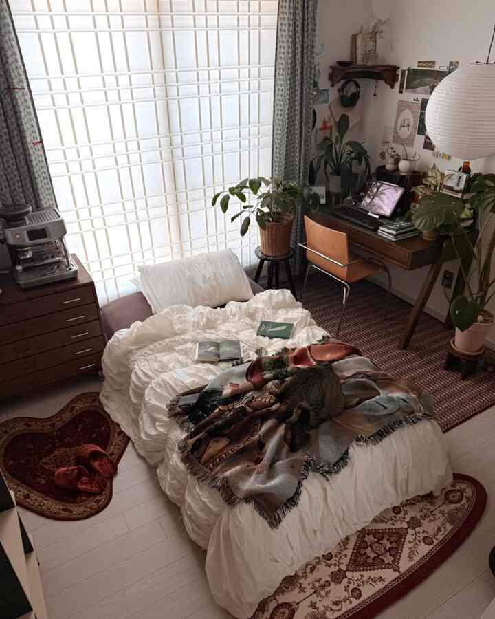 ブラウンとホワイトのトーンの寝室、中央にベッドとデスクが配置された落ち着いた空間